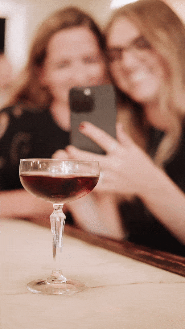 Women from Knoxville ShowIt web design agency Liberty Type smile with a cocktail as they pose for a selfie