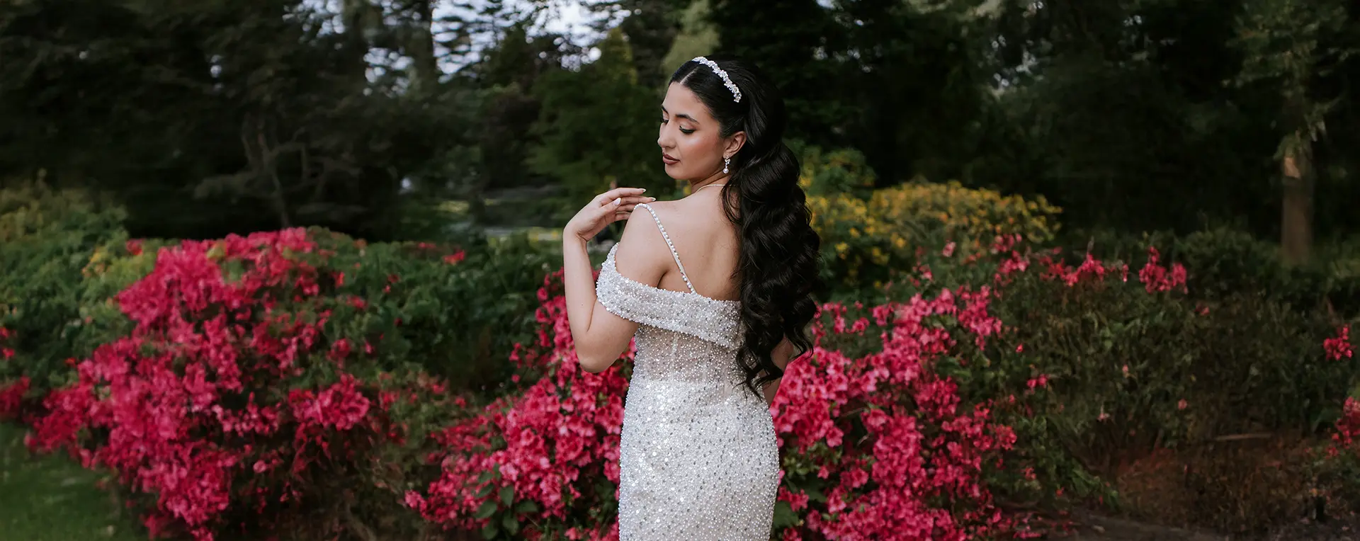 Braut im funkelnden Kleid vor Azaleen im Rosarium Park in Uetersen; sanfte Pose, künstlerische hochzeitsfotos und fine art hochzeitsfotografie