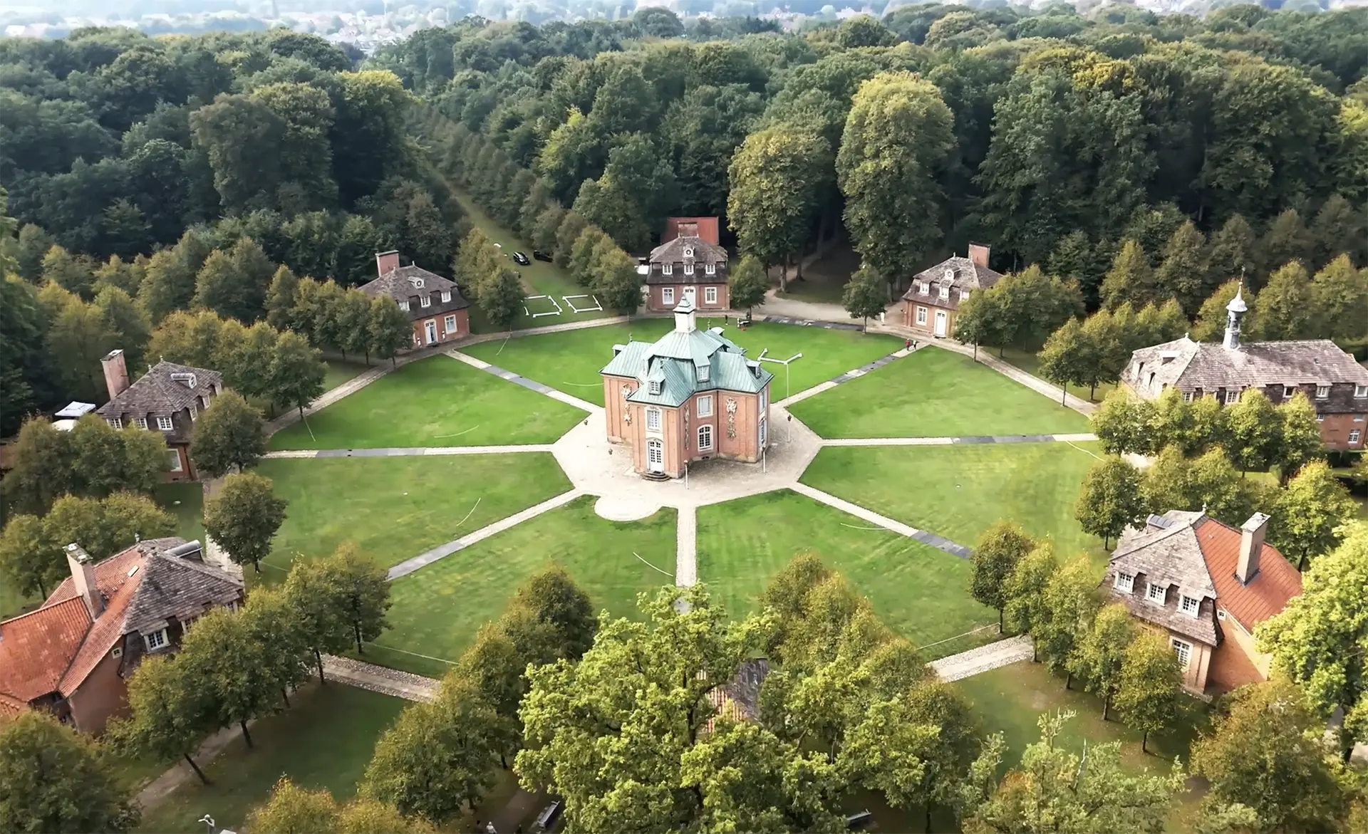 Drohne Hochzeit – Luftaufnahme einer historischen Hochzeitslocation mit Pavillon und symmetrischer Parkanlage.