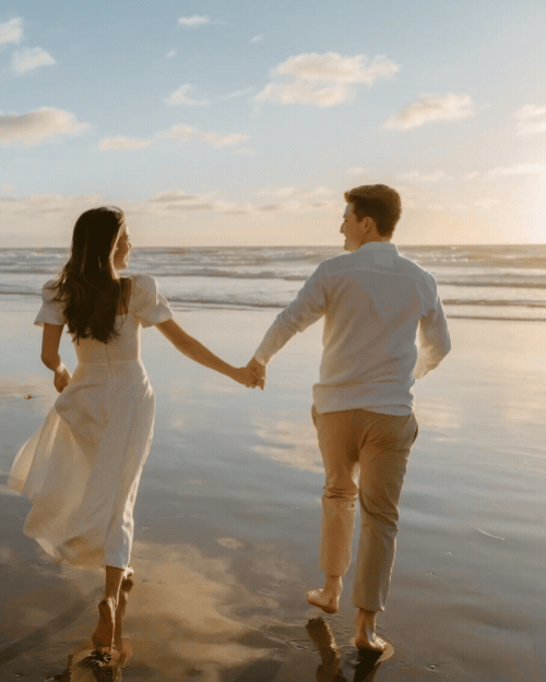 bride and groom running at beach