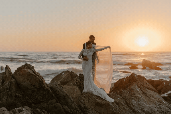bride and groom on ocean rocks
