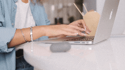 background opaque gif of hands typing on a laptop