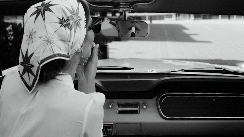 The Lovers Elopement Co - Woman applies lipstick in open top classic car on water front of Queenstown New Zealand - black and white video