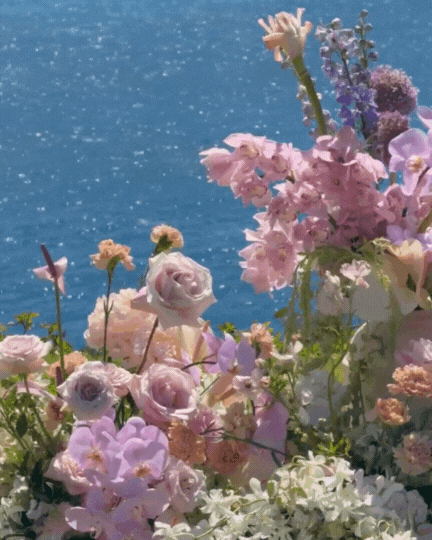 Lush tropical flower decor in front of ocean at Kauai wedding