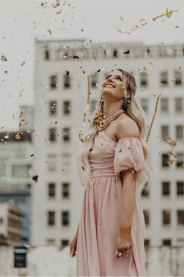 woman twirling with gold confetti