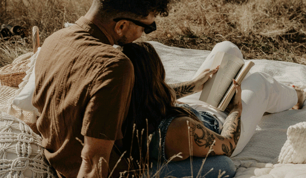 Couple kissing each other while they bend with a mountain view