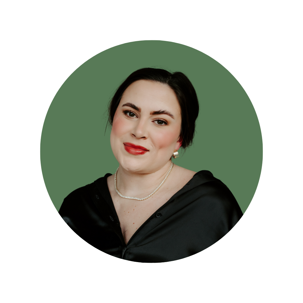Carlee M., a Web Designer Library member, wearing a pearl necklace and black satin top, smiling confidently.