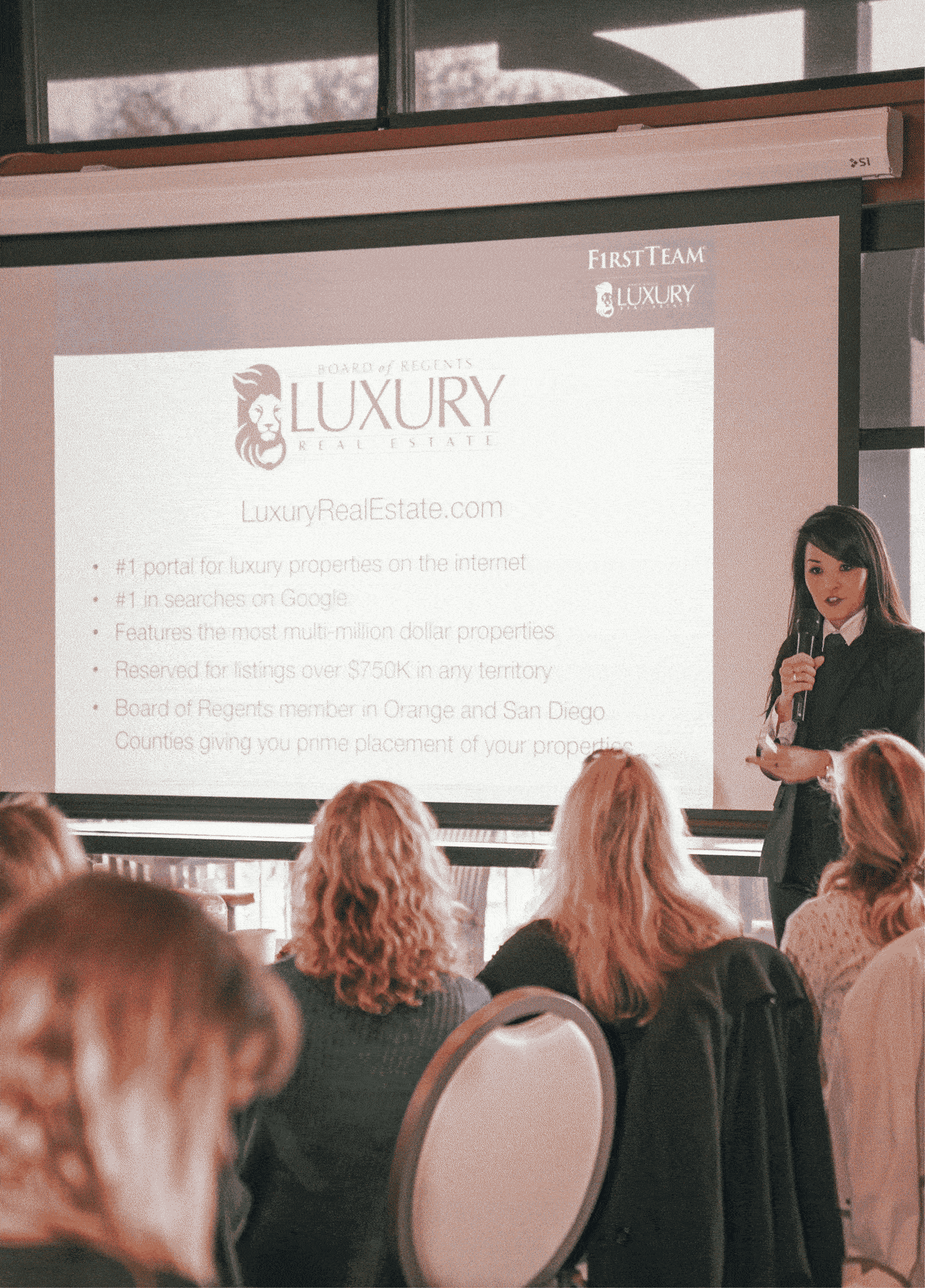 Sandy Chang presenting luxury real estate marketing strategy to a group of agents at event.