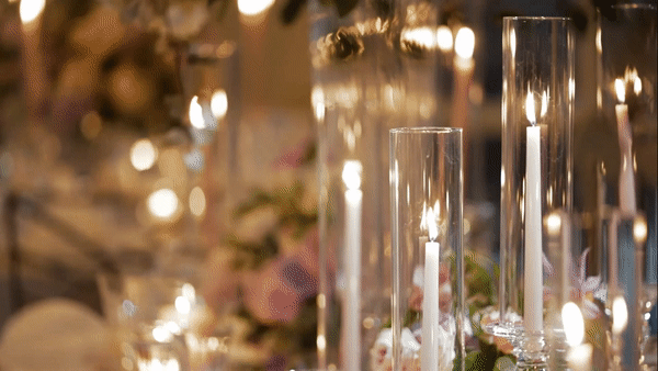 Candles flicker on wedding reception table