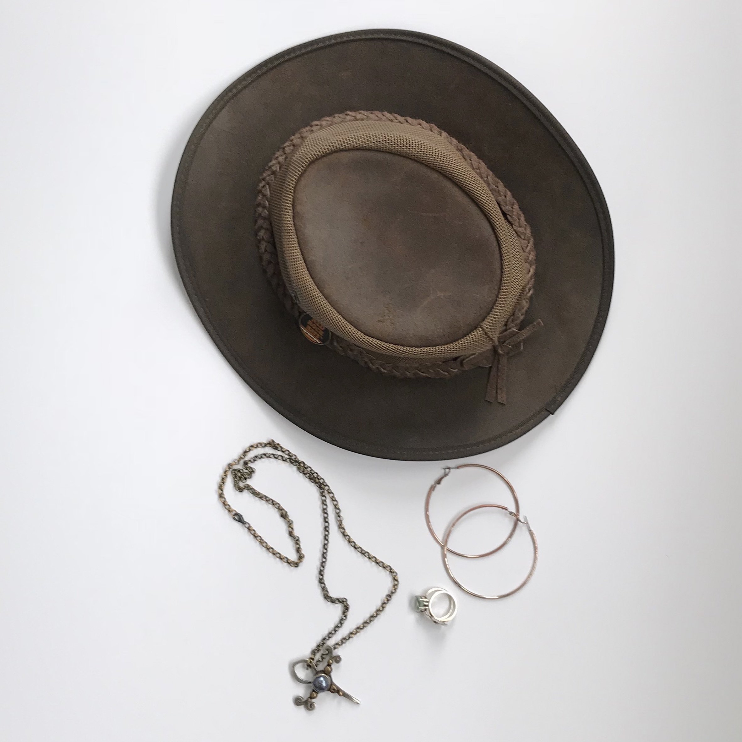 Flatlay of sunhat and jewellery that Lynda uses in her kombi packing list