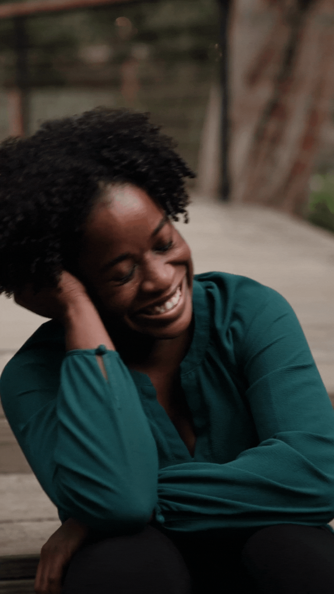 GIF of a woman smiling and laughing.