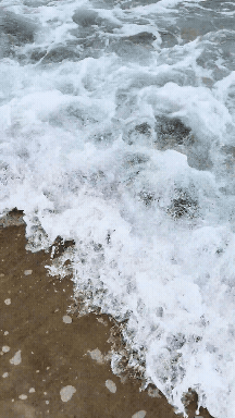 A GIF of waves crashing against the shore at Cannon Beach, Oregon, capturing the power and beauty of the ocean as the water flows in and out along the sandy coastline.