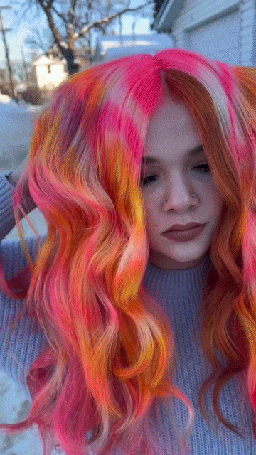 close up of woman with multi-colored hair and fringe jacket