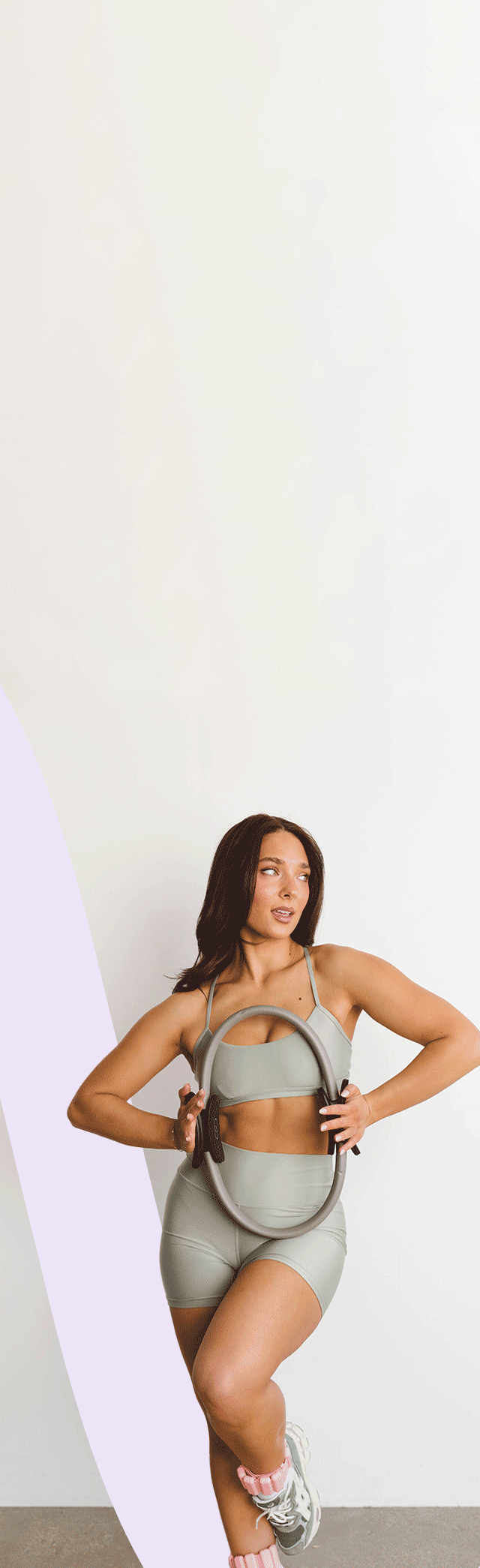 GIF of woman holding a pilates circle in workout clothes