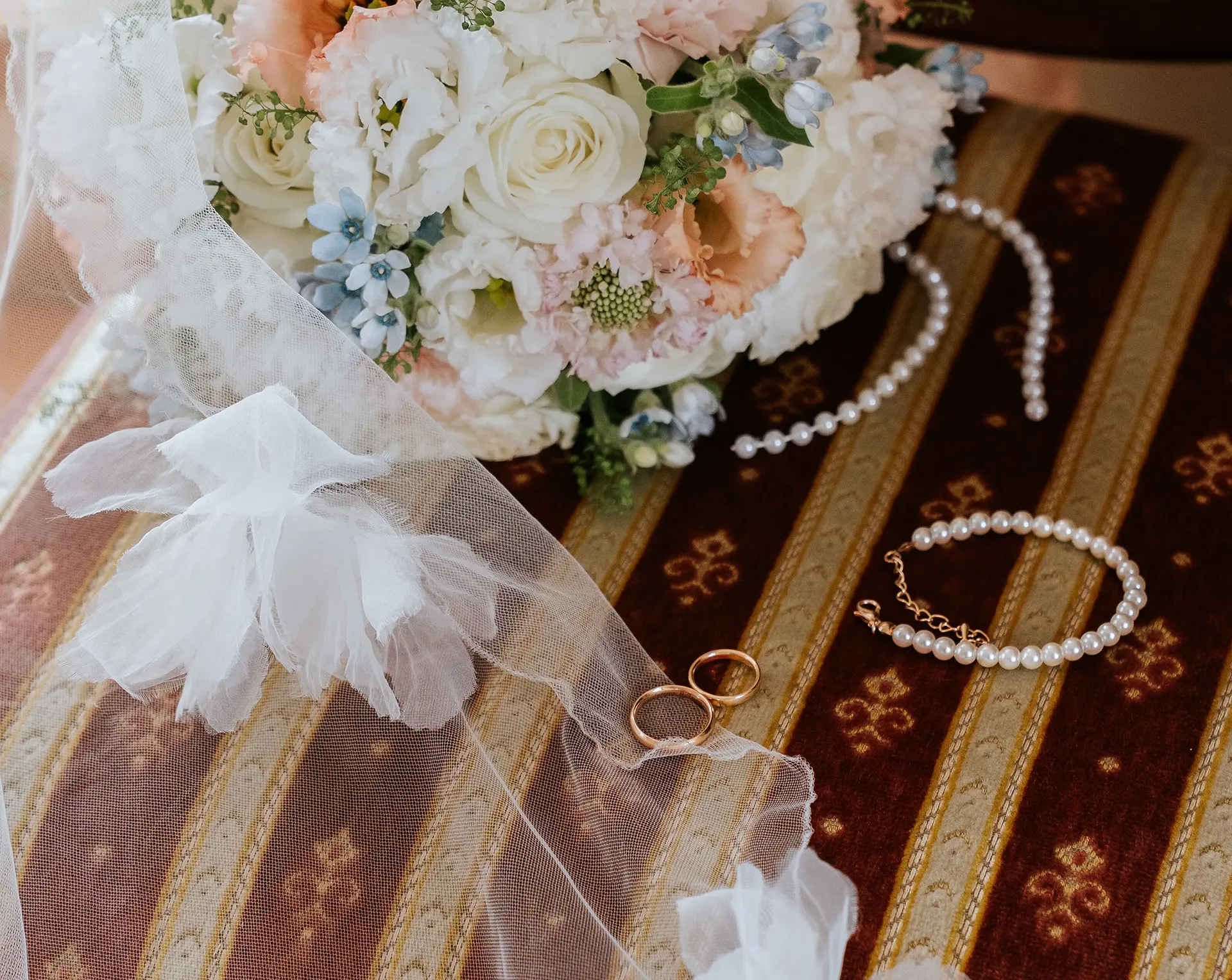 Zarte Getting-Ready-Details: Brautstrauß, Eheringe, Perlen und Schleier auf einem Vintage-Stuhl in Bonn – natürliche Hochzeitsfotografie und Hochzeitsfotografie mit Stil