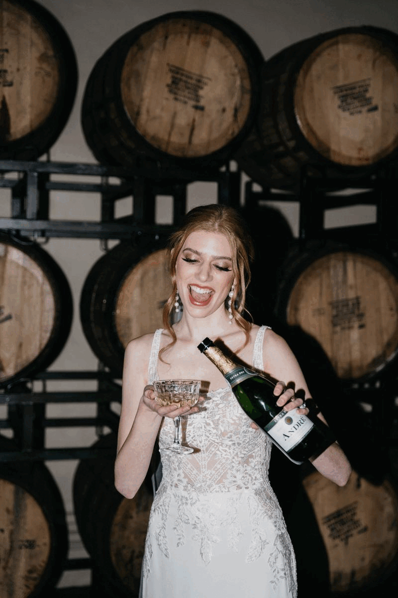 A gif of a bride bringing a glass of champagne to her lips