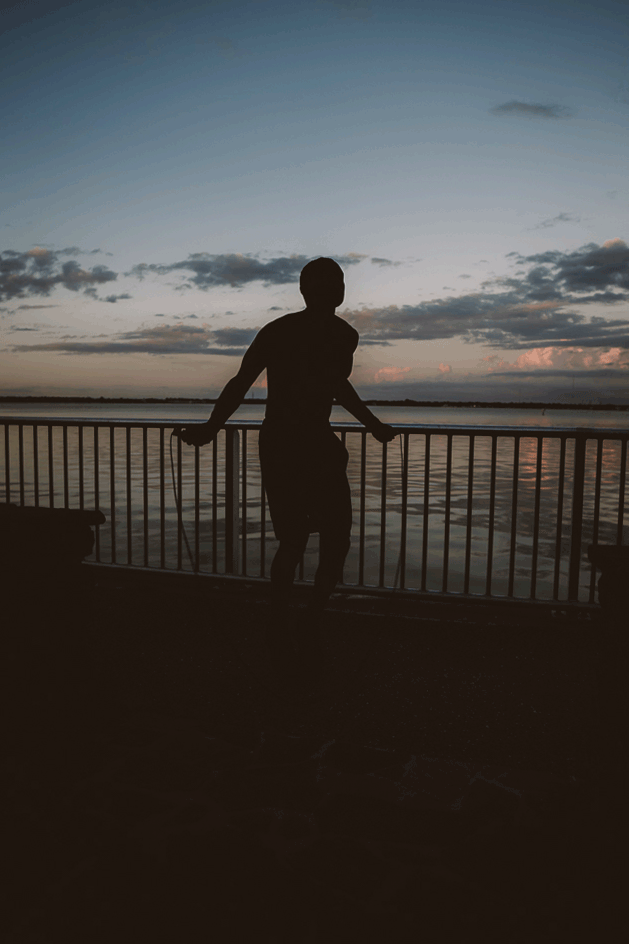 man jumping rope at dusk brand photoshoot