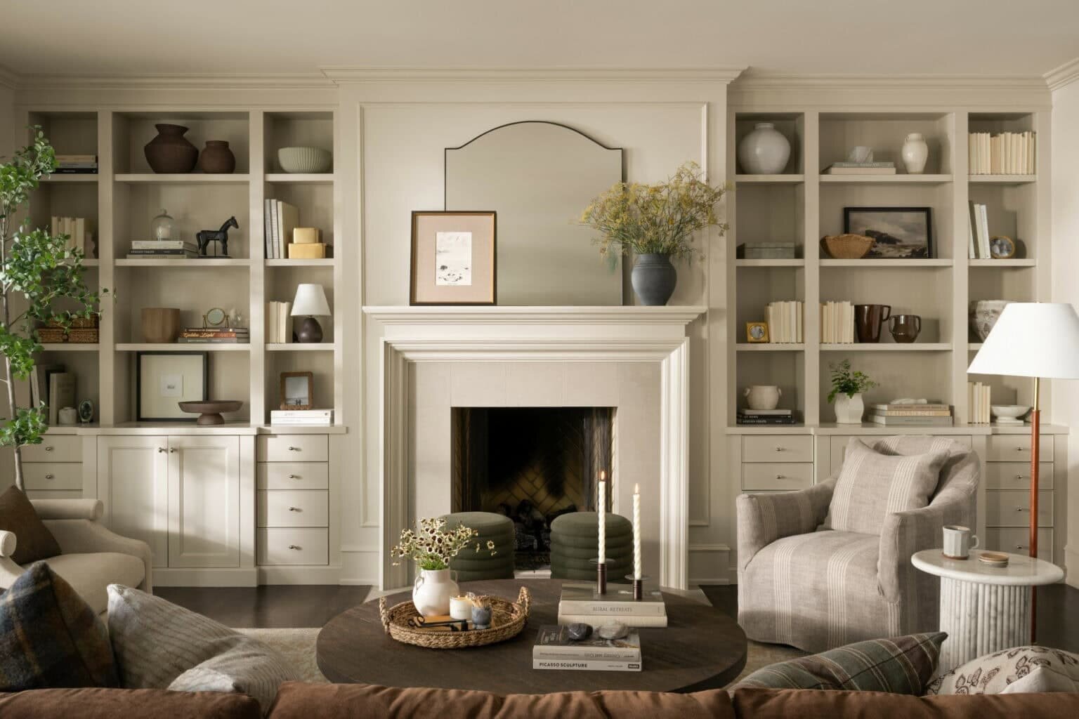 A cozy living room featuring a fireplace and well-organized bookshelves, perfect for a warm reading atmosphere.