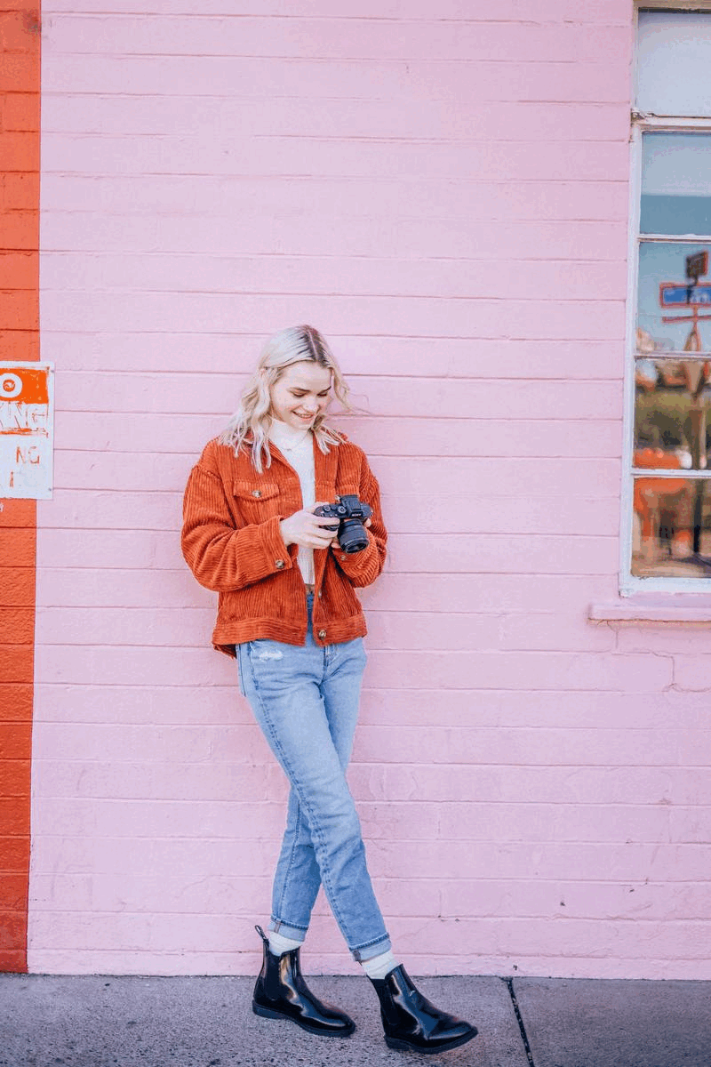 Brand color palette and mood inspiration shows young woman in jeans and orange jacket posing in front of bubblegum pink bricks