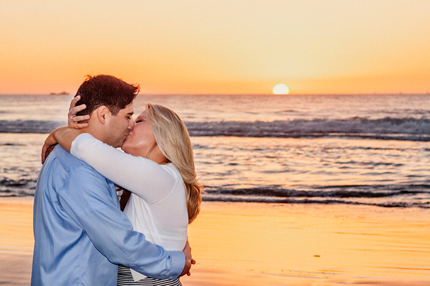 Golden hour sunset photo of a couple embracing and kissing on the beach by Wedding Photography Maimi