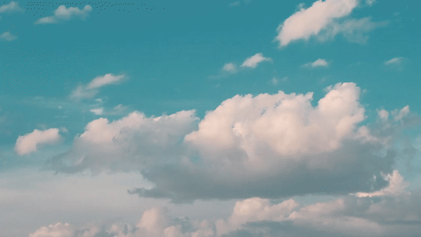 gif of white clouds in a blue sky moving from left to right  across the screen