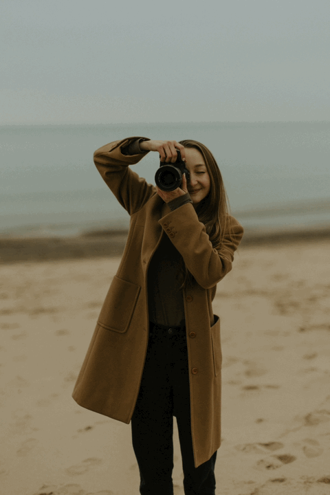 A GIF of a photographer taking a photo and then putting down her camera and smiling
