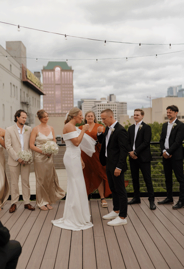 bride and groom take a tequila shot at their rooftop wedding ceremony in downtown Milwaukee at Vista MKE