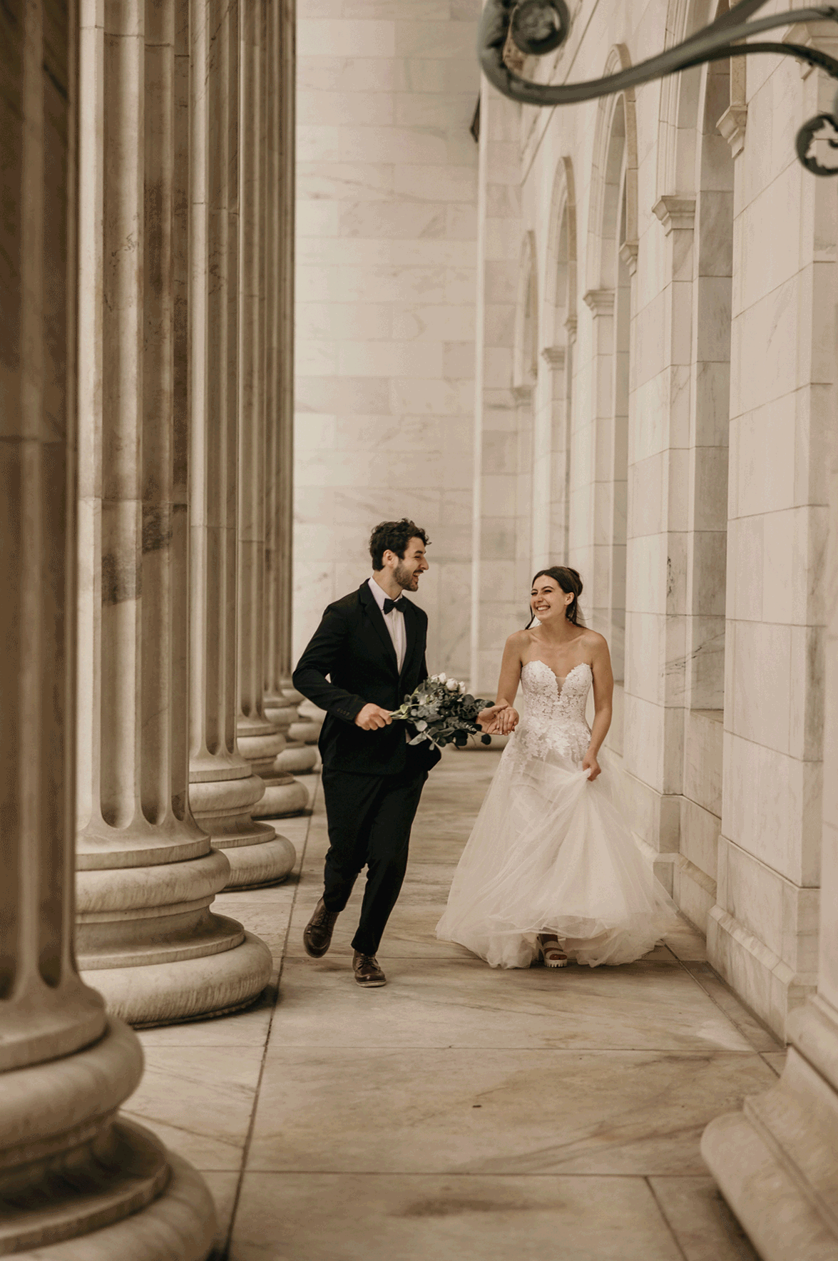 bride and groom run along byron white courthouse during denver micro wedding portraits.