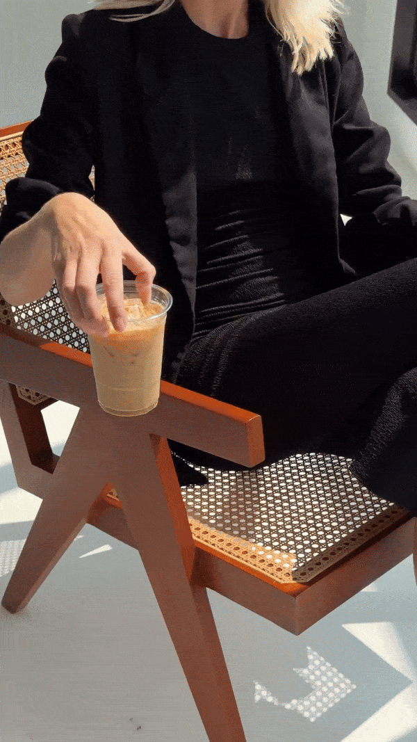 A designer sitting on a chair drinking coffee