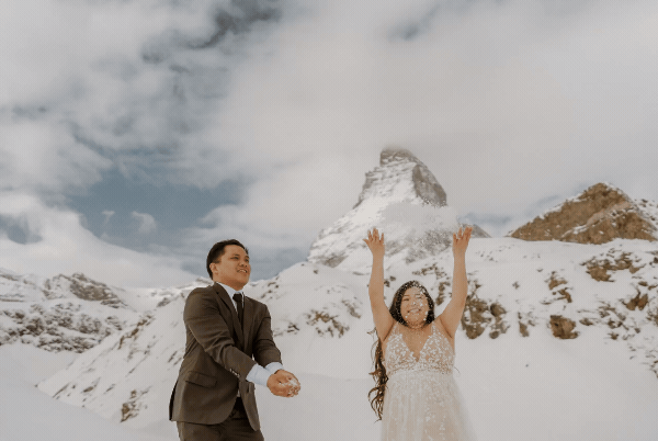 bride and groom walking in front of mountain