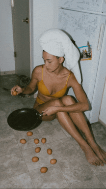 woman cracking eggs in a pan