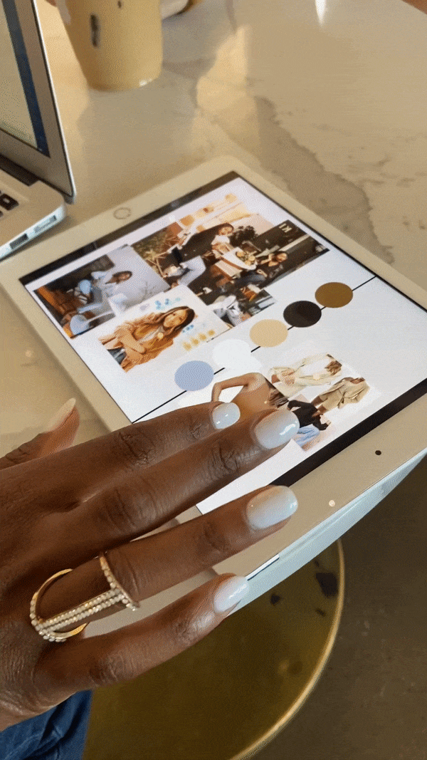Hands of Rianne Nycole showing moodboard on ipad with client at a table.