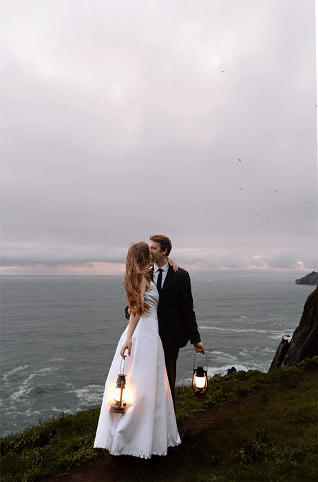Bride holding up a bouquet of flowers during a beach elopement in Michigan.