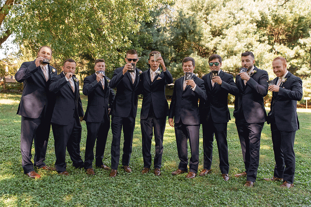 GIF of groom and his groomsmen taking a shot from their customized flasks