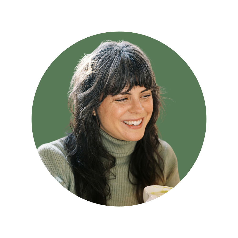 Carrie B., a Web Designer Library member, smiling warmly while holding a mug, with long hair and bangs.