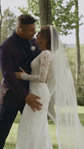 a gif of a groom in a purple suit dipping his new wife into a romantic kiss at the lodge at Indian Lake venue