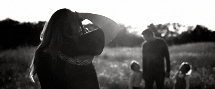 Short black and white clip of Gilllia Oler taking photos of a father and his son and daughter