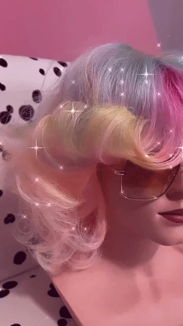 close up of woman with multi-colored hair and fringe jacket