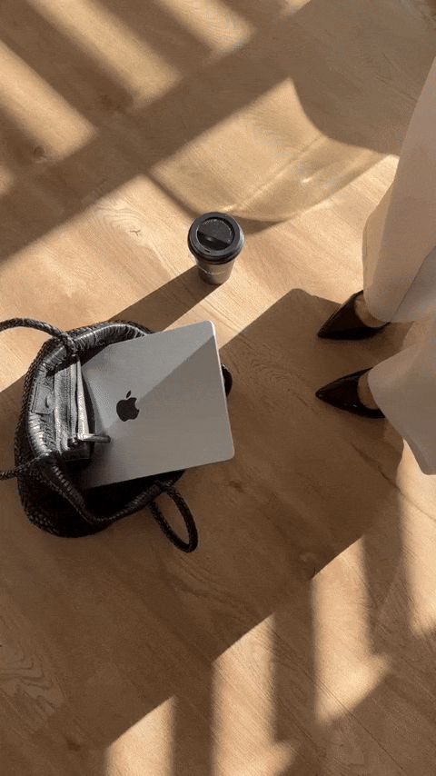 GIF of a laptop in a purse on the ground in front of a woman