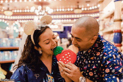 Couple bites a Disney cookie and then  kissing