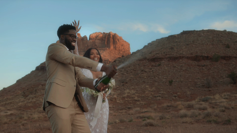 bride and groom spraying champagne after wedding  in moab