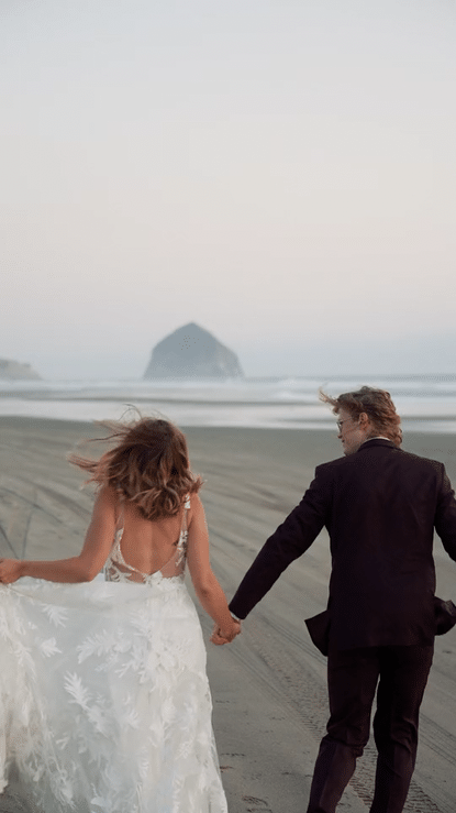 bride and groom running on beach