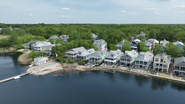 A stunning waterfront aerial shot capturing the beauty of long shore homes in North Indiana. This scenic view showcases the luxurious homes along the shoreline, surrounded by serene natural landscapes.