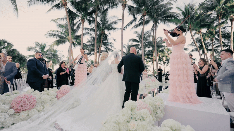 Bride entering ceremony to violinist lining the ceremony aisle