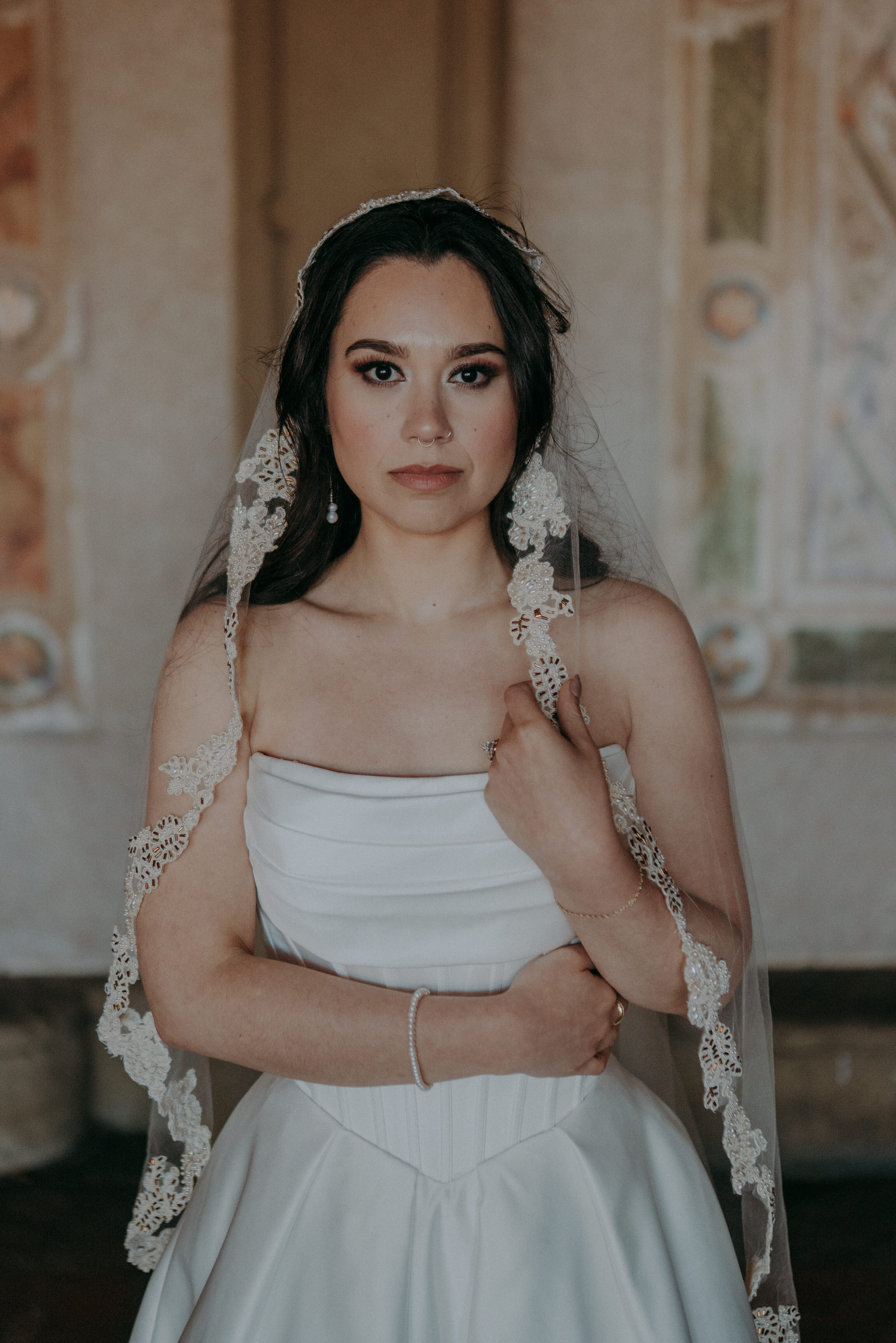Bride standing at Bethesda Terrace in Central Park with lace veil and strapless gown, frescoes in the background