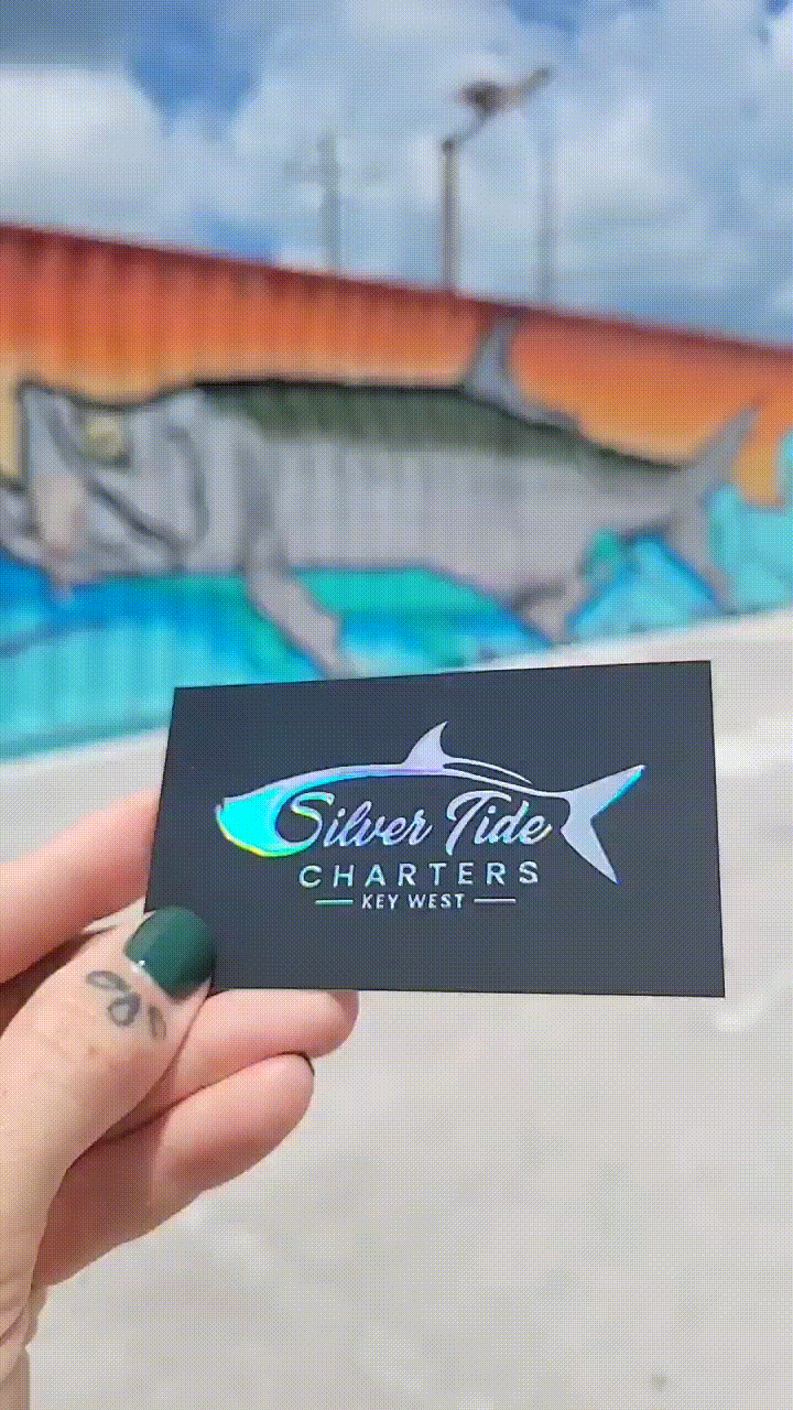 Irridescent logo over black business card reading Silver Tide Charters Key West