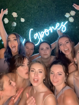 Bride and bridesmaids blow kisses in at wedding reception