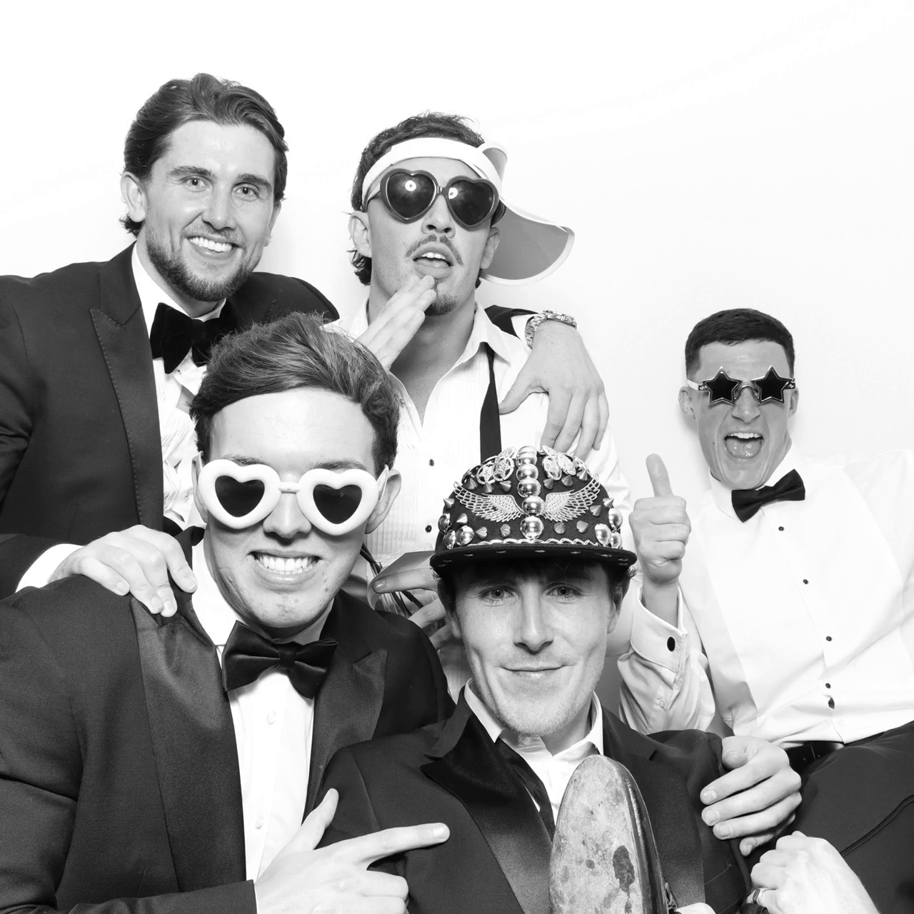 group of friends posing against a white backdrop for a B&W Kardashian style booth, during a corporate event, for Mad Hat Photo Booth at Kin House