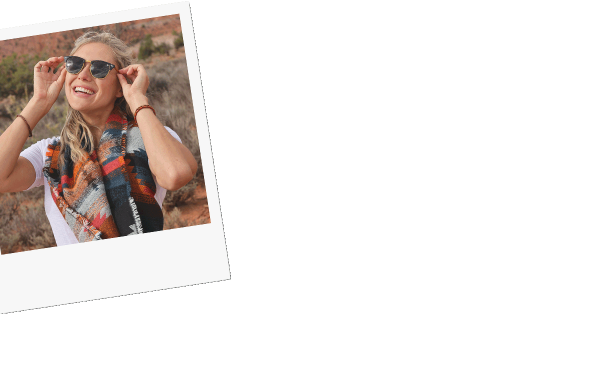 Five polaroid photos that shows a woman with blonde hair smiling in the red desert, holding her laptop. Other images shows a cactus, and camera sitting on a red tribal blanket outside.