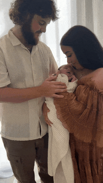 Parents holding their newborn close in a light-filled Perth studio photography session